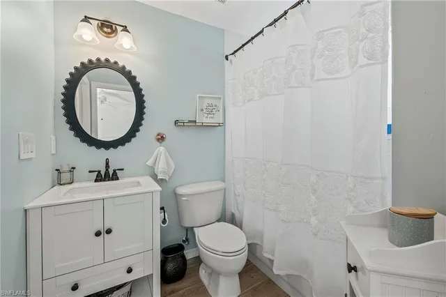 a bathroom with a toilet a sink and a mirror