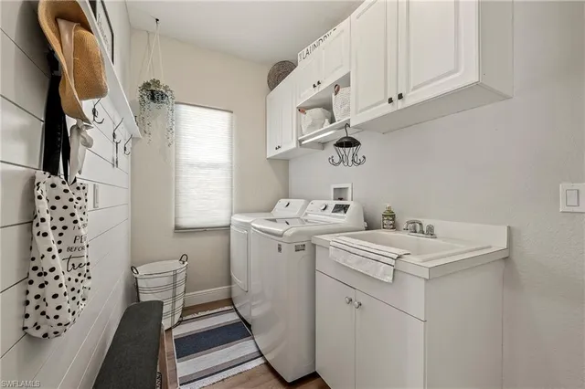 a utility room with cabinets washer and dryer