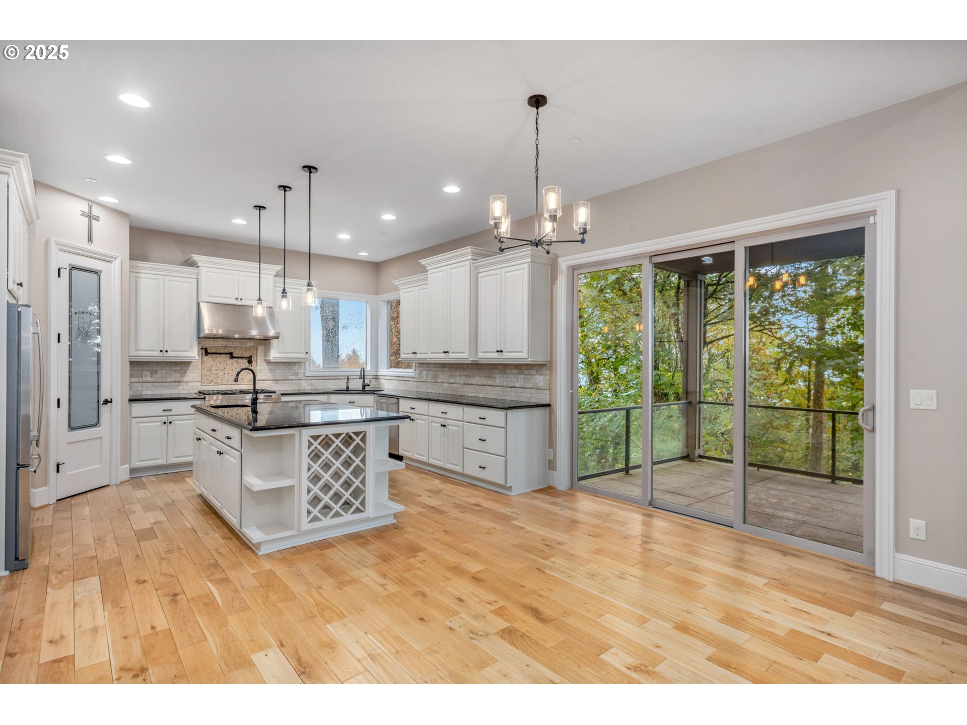 4530 Southwest Council Crest Drive Portland, OR 97239 - Photo 12 of 43 a kitchen with stainless steel appliances kitchen island granite countertop a refrigerator a sink a stove and a wooden floors