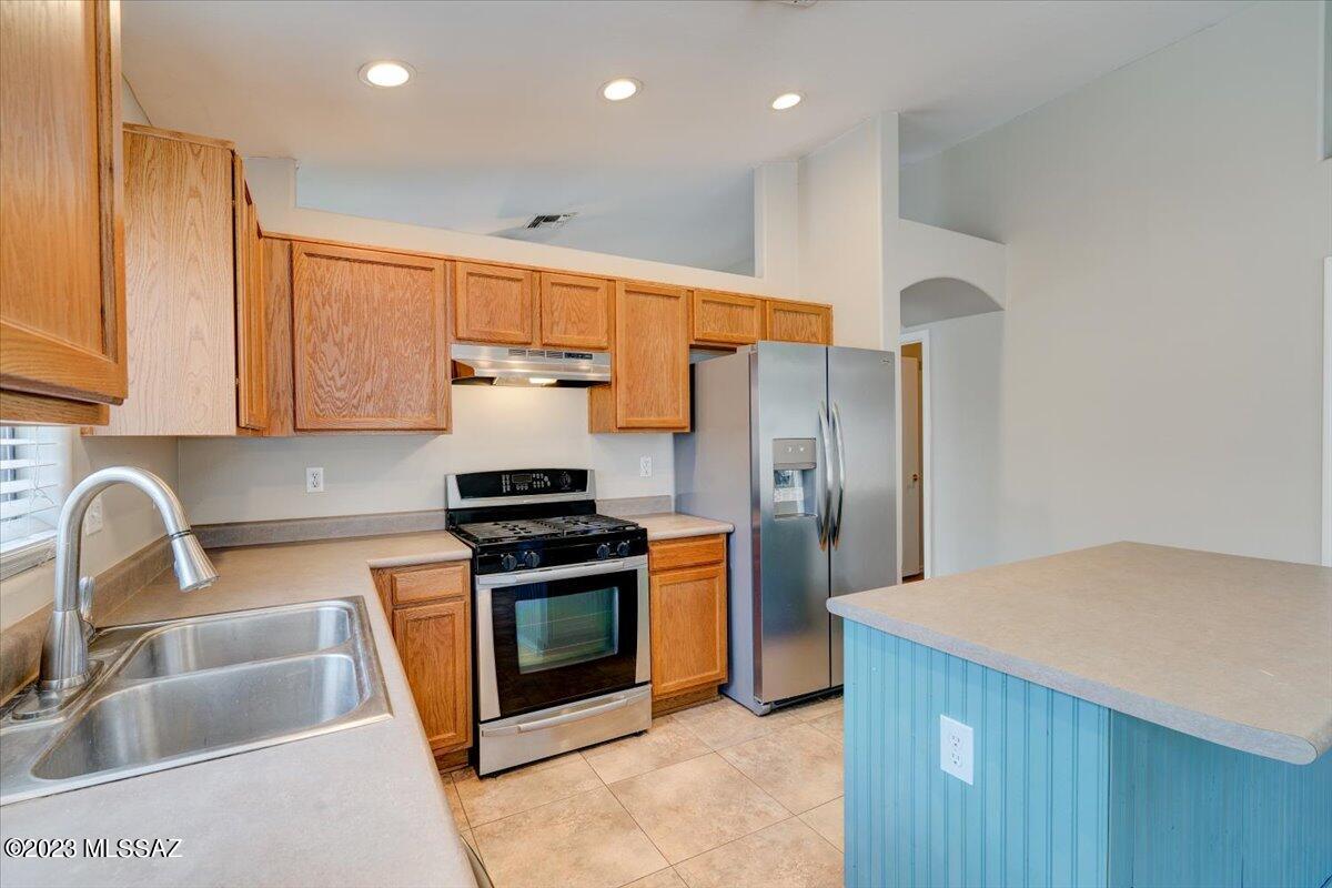4686 South Valley Road Tucson, AZ 85714 - Photo 9 of 37 a kitchen with stainless steel appliances granite countertop a sink stove and refrigerator