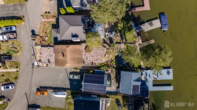 a view of a swimming pool with lawn chairs and a dining table under an umbrella