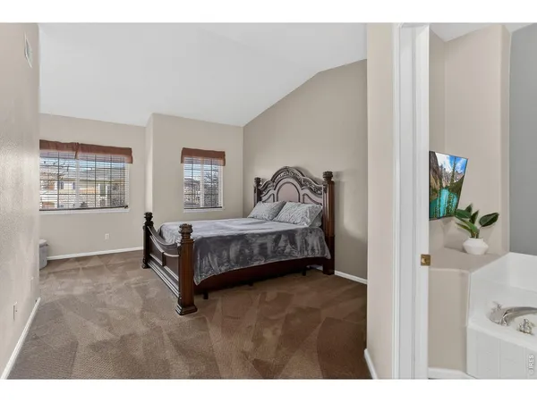 a bedroom with a bed and a view of kitchen