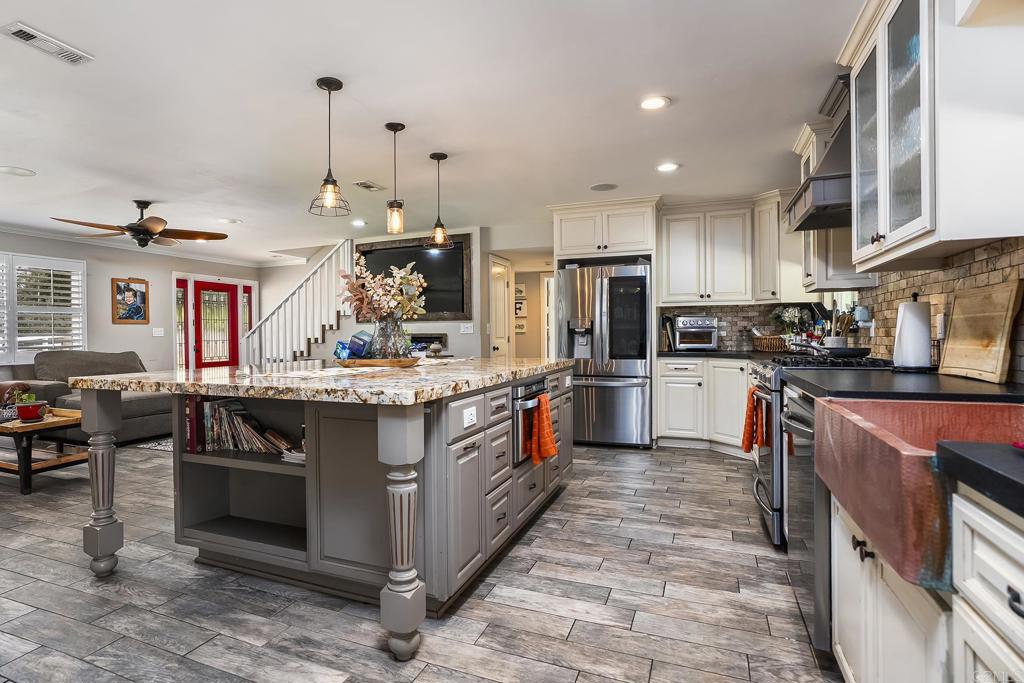 2430 Geyer Lane Alpine, CA 91901 - Photo 13 of 60 a kitchen with stainless steel appliances granite countertop a stove a sink dishwasher a refrigerator and a oven with wooden floor