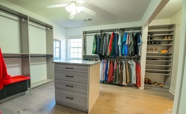 a view of walk in closet with clothes and shoes
