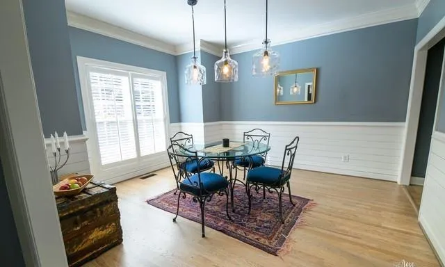 a view of a dining room with furniture a chandelier and wooden floor
