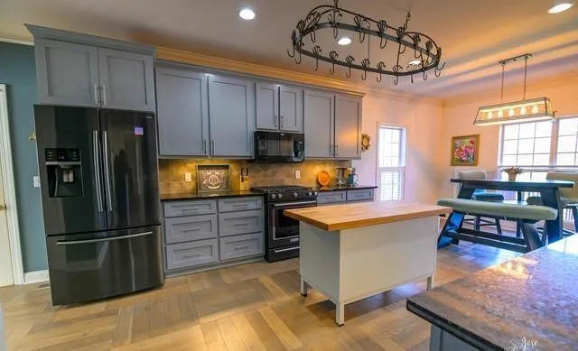 a kitchen with stainless steel appliances granite countertop a refrigerator a stove a sink and a refrigerator