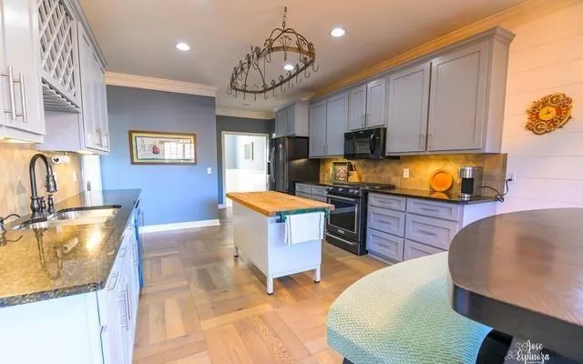 a kitchen with stainless steel appliances granite countertop a sink dishwasher a microwave oven a stove with granite countertops and cabinets