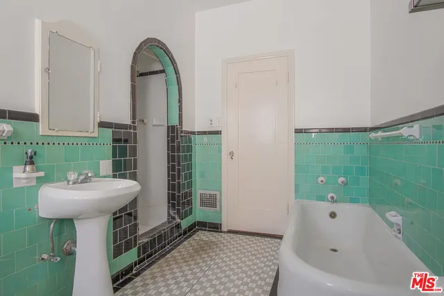 a bathroom with a sink mirror and tub