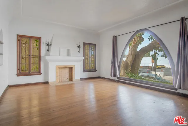 an empty room with large windows and wooden floor