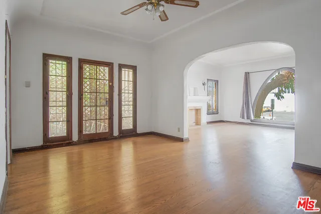 a view of an empty room with a window and wooden floor