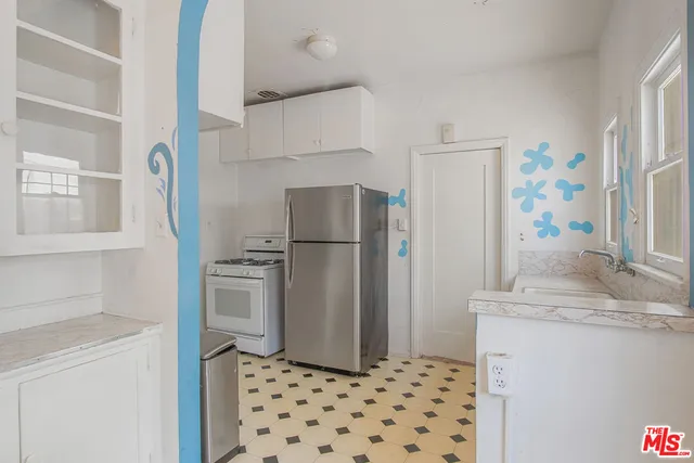 a kitchen with stainless steel appliances granite countertop a refrigerator and a sink