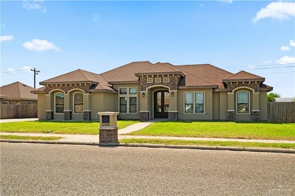 a front view of a house with a garden and yard
