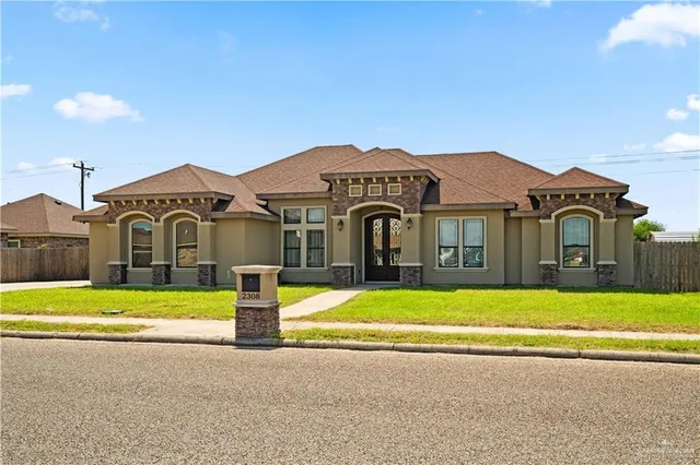 a front view of a house with a garden and yard