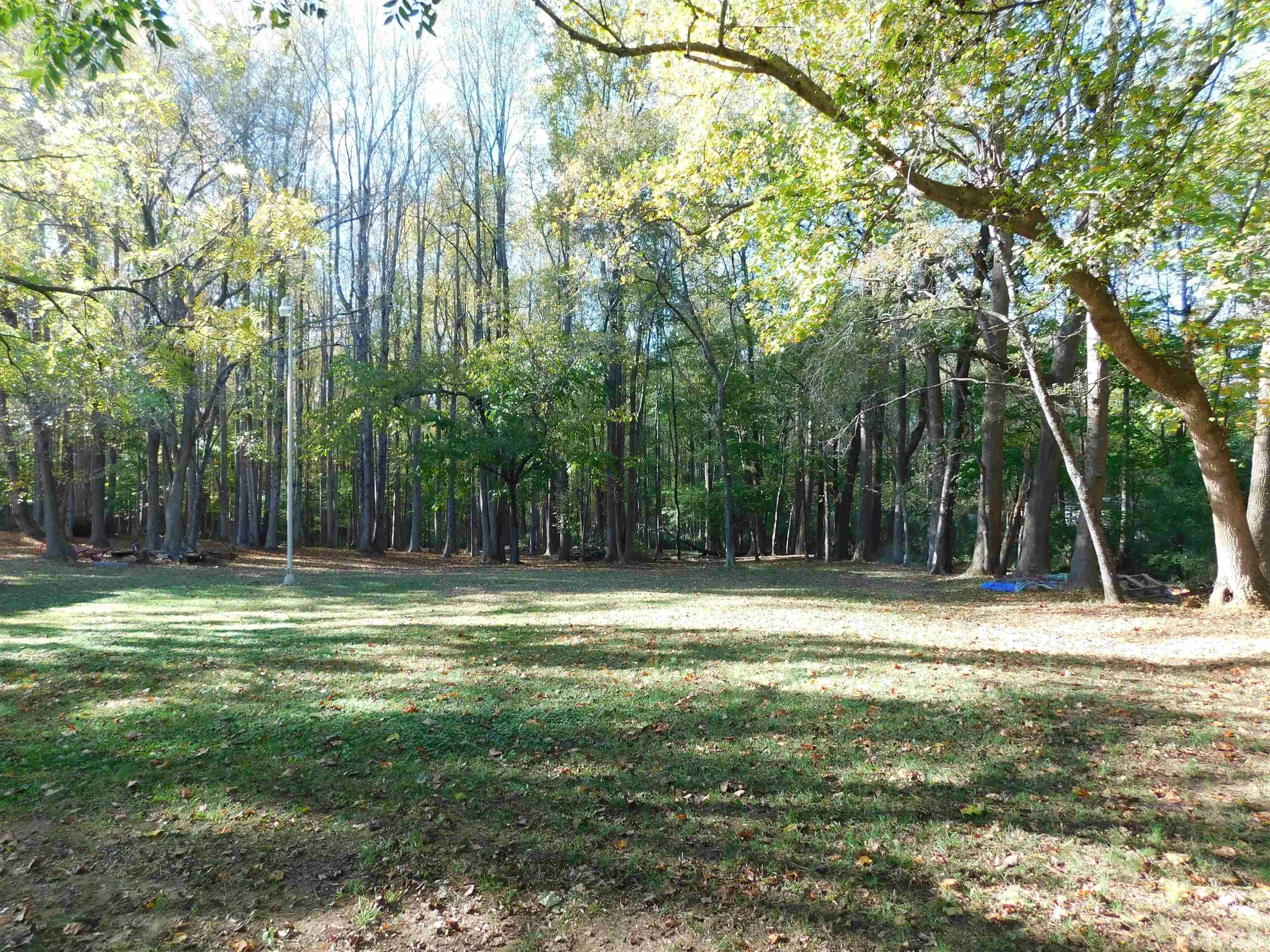 7180 Driver Road Zebulon, NC 27597 - Photo 17 of 19 a backyard of a house with trees and outdoor seating