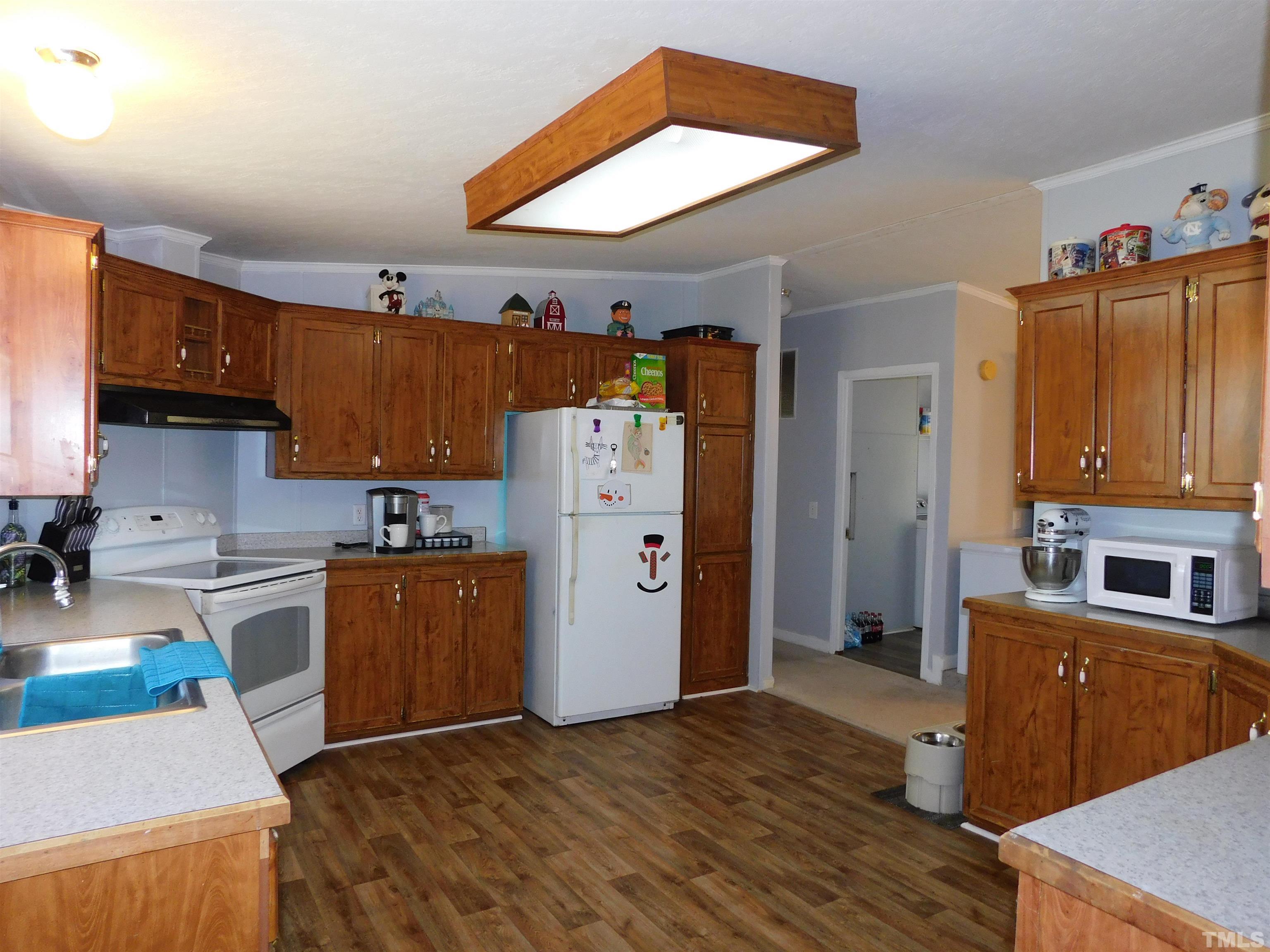 7180 Driver Road Zebulon, NC 27597 - Photo 6 of 19 a kitchen with stainless steel appliances granite countertop a refrigerator a stove and a wooden cabinets