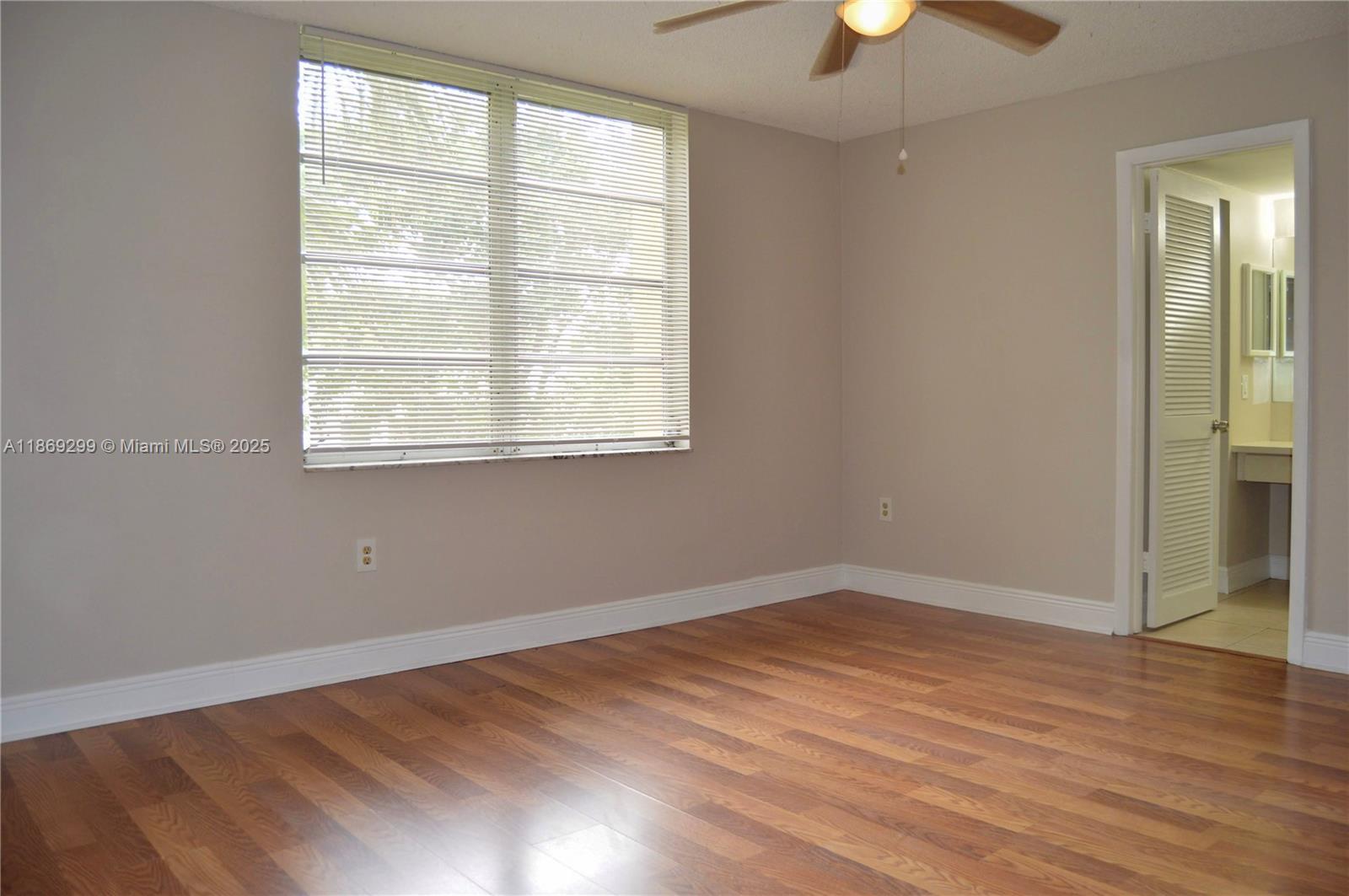 3490 Foxcroft Road, Unit B212 Miramar, FL 33025 - Photo 13 of 21 an empty room with wooden floor and windows