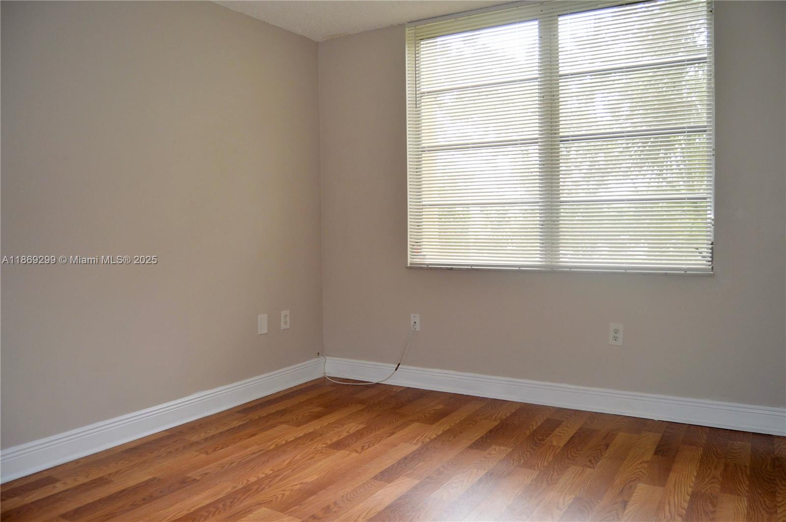 3490 Foxcroft Road, Unit B212 Miramar, FL 33025 - Photo 15 of 21 an empty room with wooden floor and windows