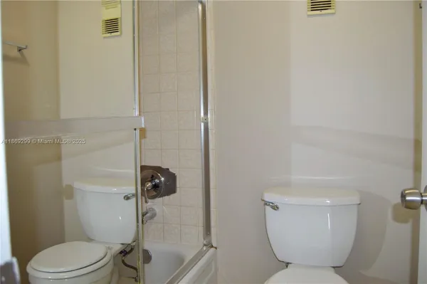 a white toilet sitting next to a bathroom sink