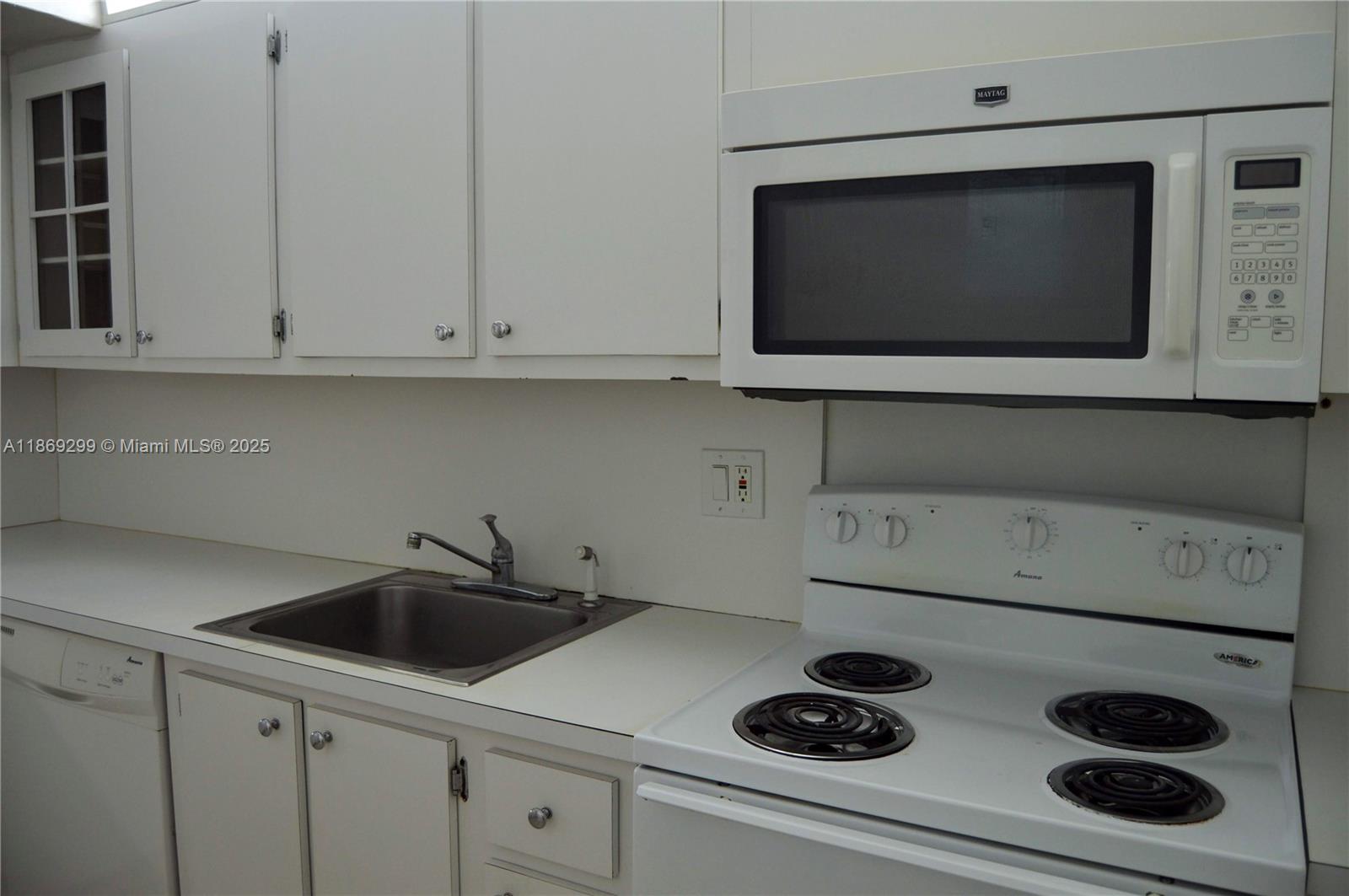3490 Foxcroft Road, Unit B212 Miramar, FL 33025 - Photo 5 of 21 a kitchen with a stove and a microwave