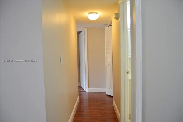 a view of a hallway with wooden floor