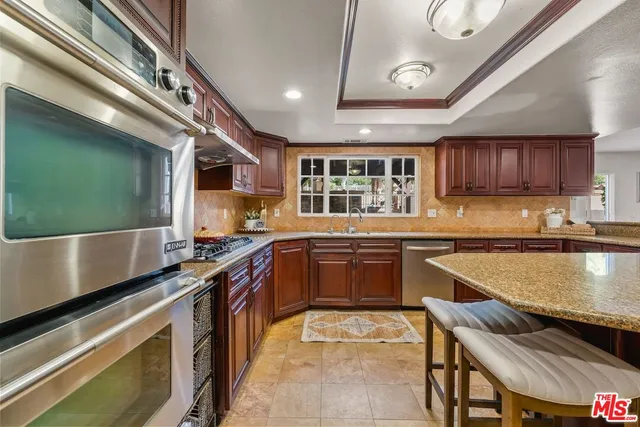 a view of a patio with table and chairs potted plants and a large tree