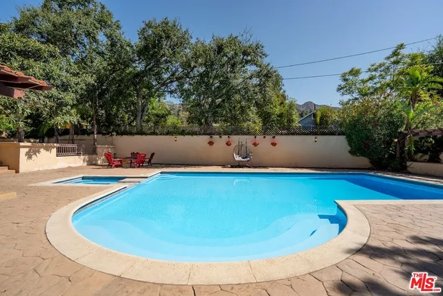 a bedroom with a bed and a dresser with wooden floor