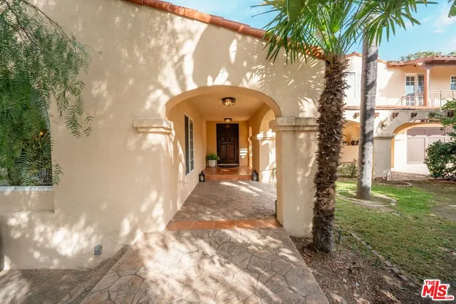 a living room with furniture a fireplace and potted plants