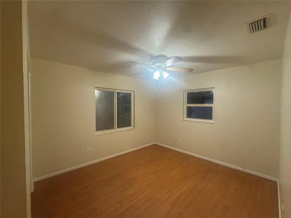 a view of an empty room with a chandelier fan