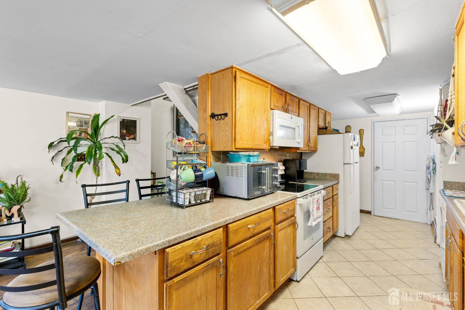 40 Fayette Street, Unit 26 Perth Amboy, NJ 08861 - Photo 7 of 20 a kitchen with stainless steel appliances kitchen island granite countertop a table chairs in it and a microwave