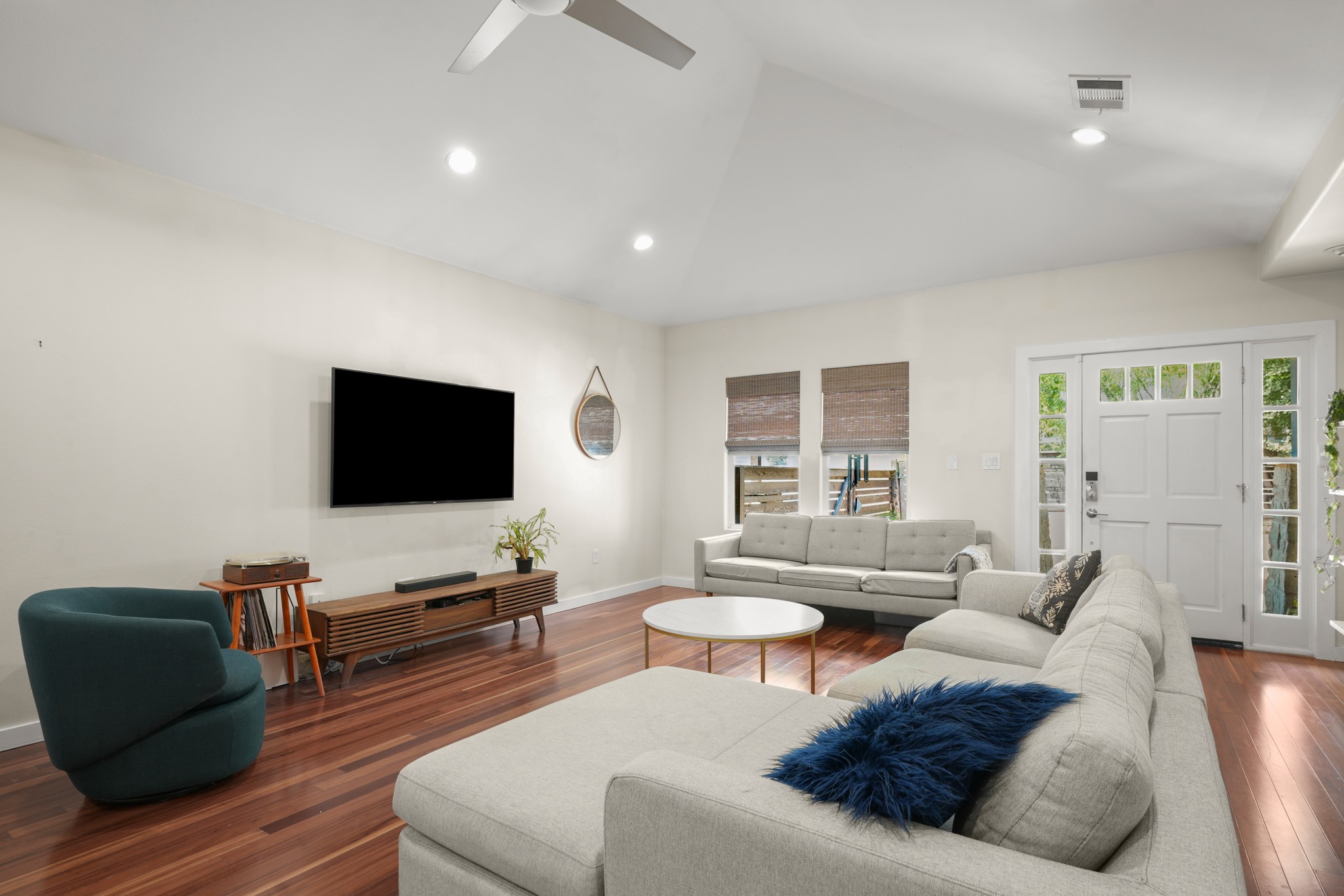 Rich hardwood floors complement the vaulted ceiling and recessed lighting in this inviting living area.