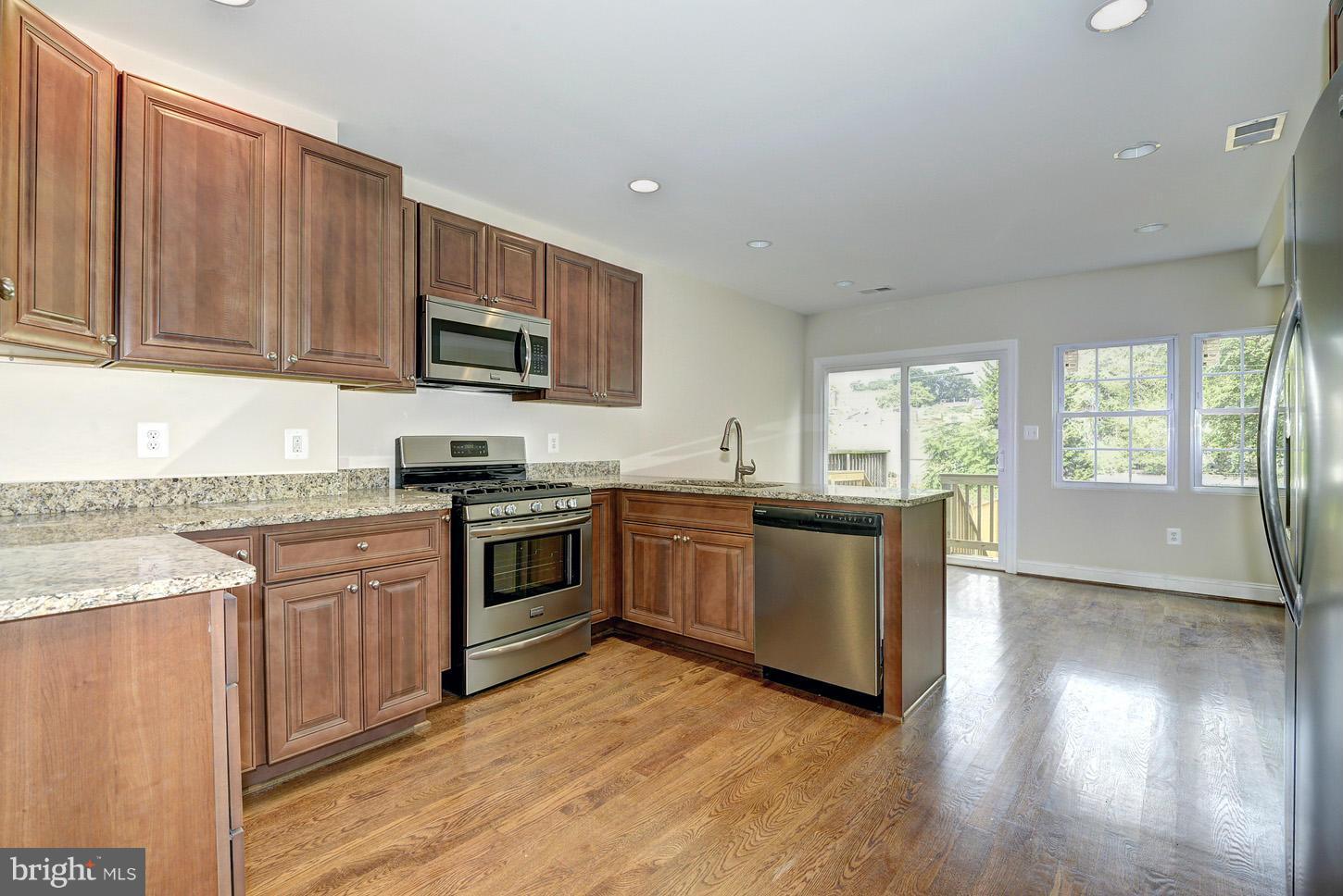 2428 4th Street Northeast Washington, DC 20002 - Photo 5 of 28 a kitchen with granite countertop wooden floors a stove and a sink