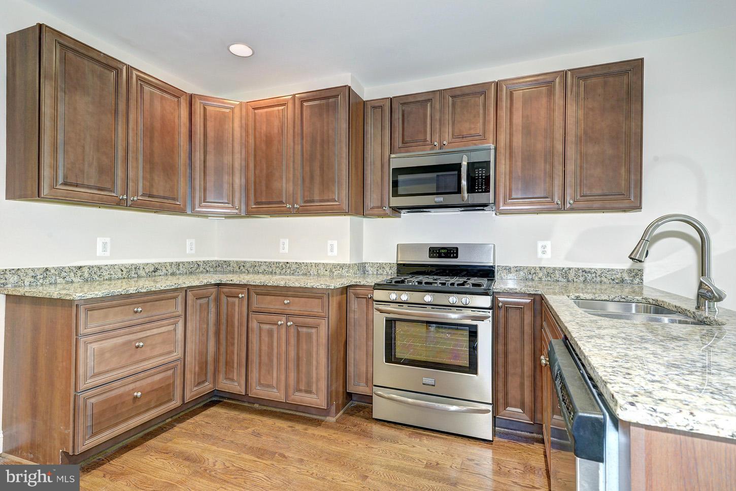2428 4th Street Northeast Washington, DC 20002 - Photo 6 of 28 a kitchen with granite countertop a stove top oven microwave and cabinets