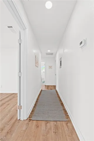 a view of a big room with wooden floor and a window