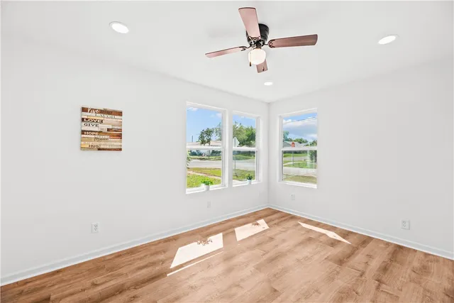 a view of empty room with window and wooden floor