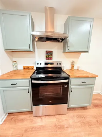 a kitchen with granite countertop a sink a stove cabinets and wooden floor