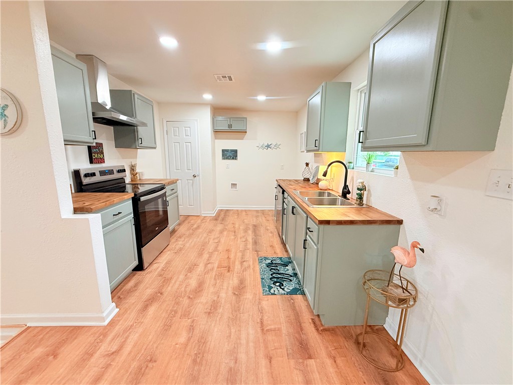 2575 San Angelo Avenue Ingleside, TX 78362 - Photo 37 of 38 a kitchen with granite countertop a sink a stove cabinets and wooden floor