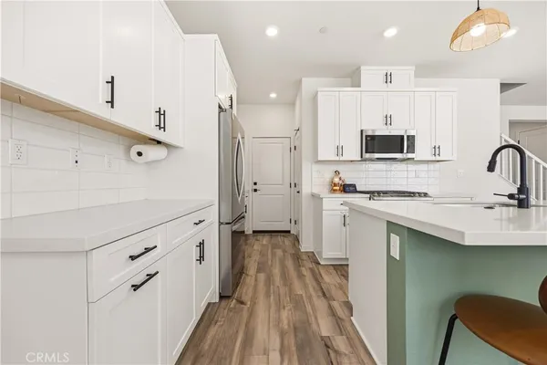 a kitchen with white cabinets appliances and sink