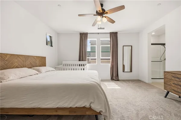 a bedroom with a large bed and a chandelier