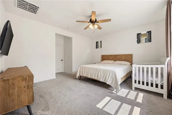a spacious bedroom with a bed and a chandelier