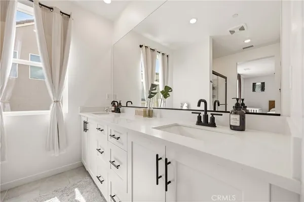 a bathroom with double vanity and a mirror