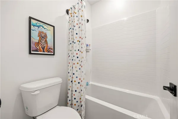 a white toilet sitting next to a bath tub