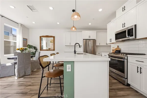 a kitchen that has a table chairs refrigerator and microwave