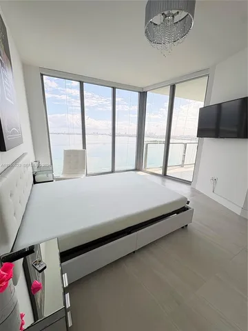 a large bed sitting in a bedroom next to a window