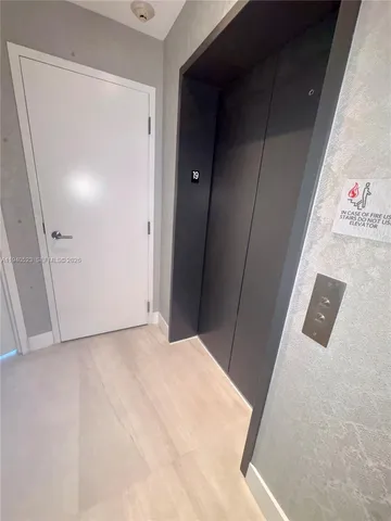 a living room with furniture large window and wooden floor