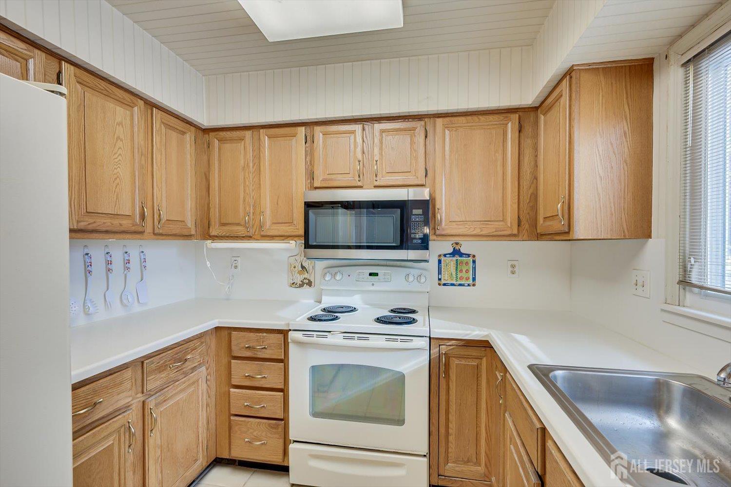 628A Windsor Way, Unit B Monroe Township, NJ 08831 - Photo 18 of 50 a kitchen with stainless steel appliances granite countertop a sink stove and microwave