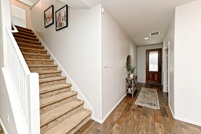 a view of a hallway with wooden floor and staircase