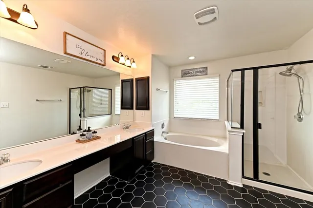 a bathroom with a double vanity sink a mirror and a bathtub