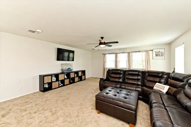 a living room with furniture ceiling fan and a window