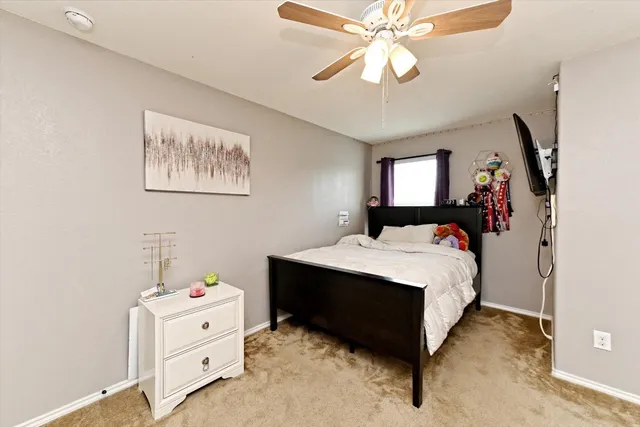 a bedroom with a bed and a chandelier fan