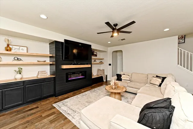 a living room with furniture a flat screen tv and kitchen view